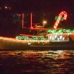 A candy-cane lit boat plies the waters off Port Orchard during a past Port Orchard Yacht Club Lighted Boat Parade. (File photo)