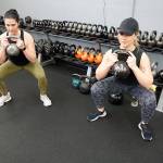Co-owners Kristi McGee (left) and Sydnie Kittelson work out with kettlebells. (Mike De Felice photo)