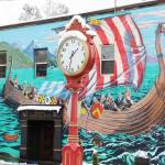 The red of the clock shines bright against the white of the snow.