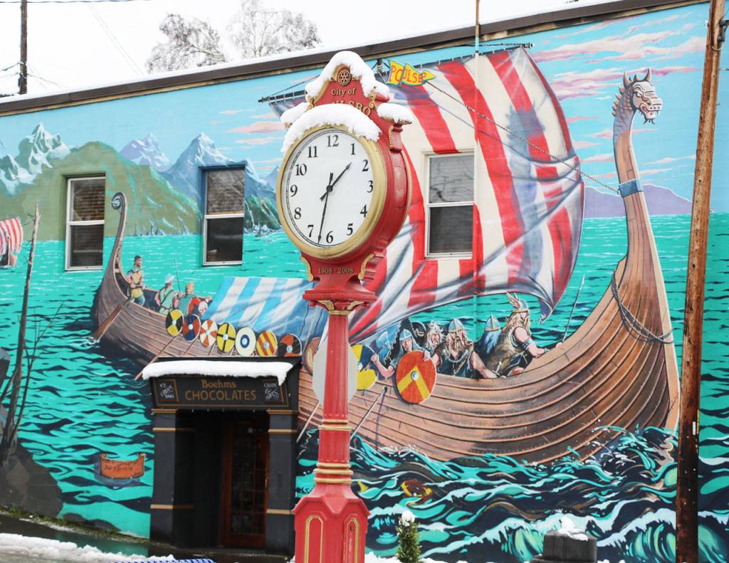 The red of the clock shines bright against the white of the snow.