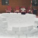 Shawn Peterson shapes the blocks of snow piece by piece as he helps build an igloo on a snowy day. (photo by Stella Peterson)