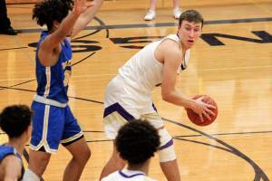 North Kitsaps Logan Chmielewski looks for an open teammate as he is defending by Bremertons Kimo Retome. Chmielewski finished his teams 84-55 win over the Knights with 12 points. (Mark Krulish/Kitsap News Group)