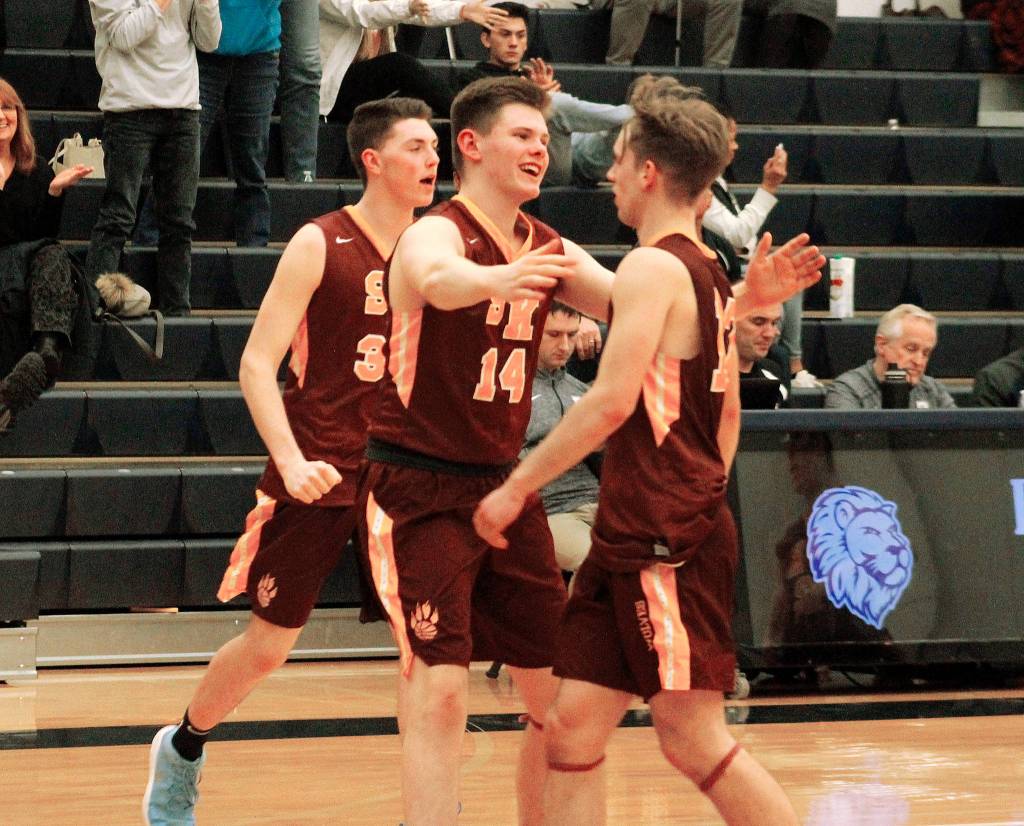 Jack Kees (14) and Kyler Kelso rush out to celebrate with Eli Mackie (12) after time expired in South Kitsaps 64-61 double-overtime victory over Bellarmine Prep. (Mark Krulish/Kitsap News Group)