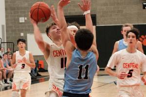 Colby White looks to get up and over Gig Harbors Christopher Parrish (11) for a basket. White scored 25 points in his teams 50-49 loss. (Mark Krulish/Kitsap News Group)