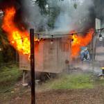 Taken as firefighters sped to the scene, this photo shows heavy fire engulfing a sleeping cabin after a cell phone charging cord apparently sparked a blaze in the 12 x 12 wooden structure. (photo submitted by NKF&R)