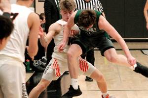 Peninsulas Cole McVay and Central Kitsaps Colby White battle for a loose ball in the first quarter of their district playoff game. (Mark Krulish/Kitsap News Group)