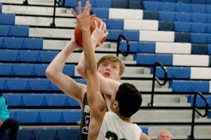Olympics Caleb Erickson tries to get a shot up and over Port Angeless Damen Ringgold (22) in Wednesdays 72-55 loss. (Mark Krulish/Kitsap News Group)