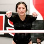 Kelli Stevens leaps for the high bar during her routine on the uneven bars. (Mark Krulish/Kitsap News Group)