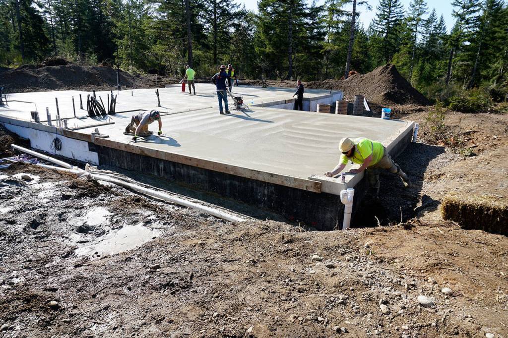 Pavers finish smoothing poured cement for the foundation of Keith Sekoras new home, now under construction in South Kitsap. The specially designed home will accommodate Sekoras special needs, all on one floor. It is being paid for by the nonprofit organization Homes for Our Troops. (Mike De Felice | Kitsap Daily News)