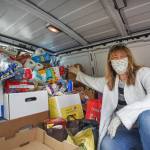 John L. Scott Poulsbo broker Lisa Diehl poses early in the day with some of the first donations collected for the Poulsbo offices food drive. (Photo courtesy of John L. Scott)