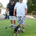 The Carbajal father-son golfing duo Rich Sr. (left) and Richard Jr.  and their dachshund-beagle mix, Stewie  are on the Village Greens Golf Course links six days out of the week now that coronavirus restrictions have been eased. (Bob Smith | Kitsap Daily News)