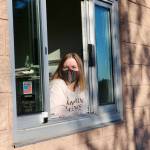 <em>Jenna DeTrapani, owner of Poulsbos newest shop, BookIt Nook, hangs out of the drive-thru window, ready for the next customer. </em>							 Ken Park/North Kitsap Herald photographs
