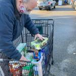 A contributors foodstuff donations are gathered up in the parking lot of the South Kitsap Helpline food bank. (Bob Smith | Kitsap Daily News)