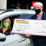 Teri Myers of Backpacks for Kids of Port Orchard (left) receives a ceremonial check from Shawn Gilfedder, president/CEO of Kitsap Credit Union, for the nonprofits program during the Cash & Dash event in Bremerton. (Kitsap Credit Union photo)