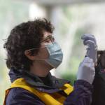 Suquamish Tribe Community Health nurse Mickenzy Cordova prepares a dose of the COVID-19 vaccine for a Tribal Elder during a drive-thru vaccination clinic at Port Madison Indian Reservation on Tuesday. (Jon Anderson)