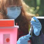 Suquamish Tribe’s Health Officer Dr. Barbara Hoffman prepares a dose of the COVID-19 vaccine for a Tribal Elder during a drive-thru vaccination clinic at Port Madison Indian Reservation on Tuesday. (Jon Anderson)