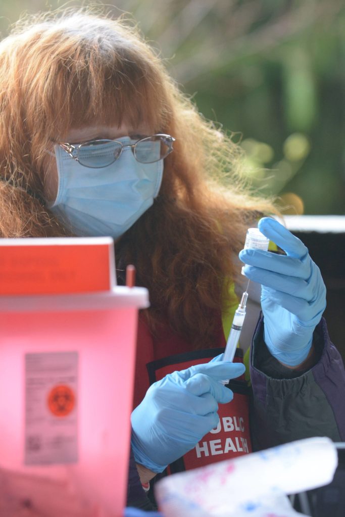 Suquamish Tribe’s Health Officer Dr. Barbara Hoffman prepares a dose of the COVID-19 vaccine for a Tribal Elder during a drive-thru vaccination clinic at Port Madison Indian Reservation on Tuesday. (Jon Anderson)