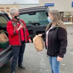 Itinerant baker Sandi Fleury delivers a tasty treat to customer Anna Herrera, who met up in a Mile Hill Drive parking lot last week. (Bob Smith | Kitsap Daily News)