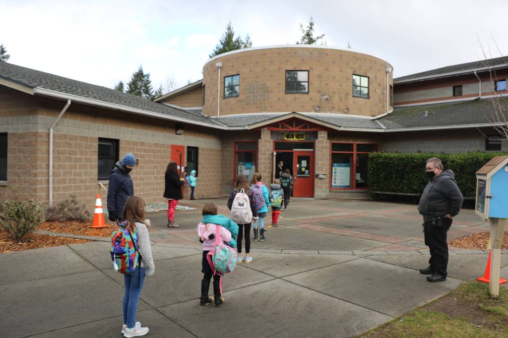 Yellow feet markers are used as space reminders for students to stay 6 feet apart while in line.