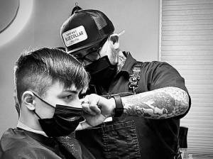 Former policeman and now barber Mike Perry gives a haircut at his new business in downtown Poulsbo.
