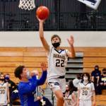 Everett Moore gets up and over the Olympic defense for a shot attempt. Moore hit four 3-pointers in Bainbridges win over the Trojans. (Mark Krulish/Kitsap News Group)