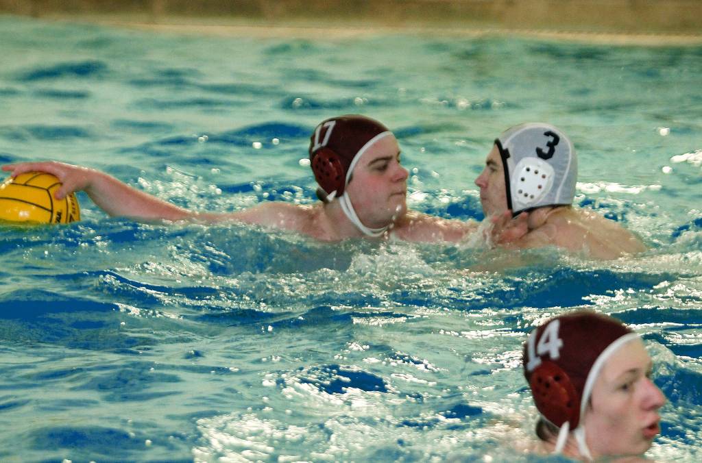 Kincaid Tyas (17) tries to hold off a charging Rylan Hopp as he sets up a pass. (Mark Krulish/Kitsap News Group)