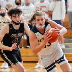 Bainbridge senior Alan Ulin takes the ball to the hoop as hes chased by North Kitsaps Jonas La Tour. (Mark Krulish/Kitsap News Group)