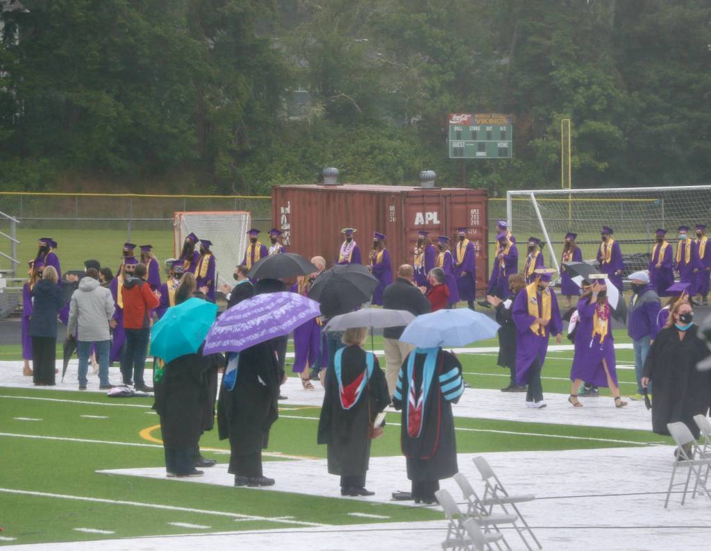 Out came the umbrellas as the rain began to fall on the graduates as they walked to the stage. (KPark/NKH).