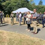 A small group of onlookers, including Port Orchard Mayor Rob Putaansuu (in foreground), listen to Navy officials laud the start of the fuel tank storage modernization project at the Manchester Fuel Depot last Friday. (Bob Smith | Kitsap Daily News)