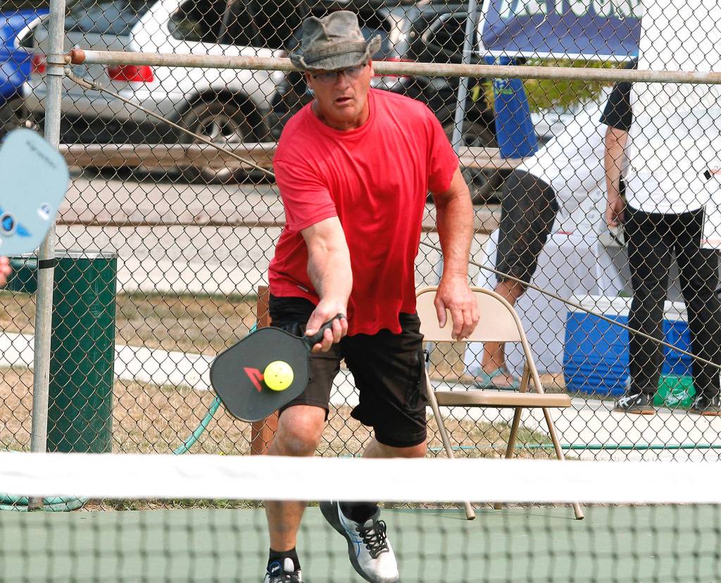Don Sickle of Bainbridge Island makes a play at the net during a medal match in the Mixed Doubles tournament. Sickle and his partner, Kim Hemingway, won silver in the 3.0, 50+ group. (Mark Krulish/Kitsap News Group)