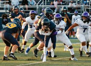 Bainbridge running back Matt LeDorze crashes through the line in the Spartans opening night game against Garfield. (Mark Krulish/Bainbridge Island Review)
