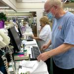 Pharmacist Ken Paskett stays busy filling orders on the South Park Pharmacys last day of business on Sept. 16. Working alongside Paskett is technician Chellie Butler. (Bob Smith | Kitsap Daily News)