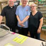 Pharmacist Ken Paskett (center) is joined by his son Jeff Paskett (left) and pharmacy technician Laura Niemann behind the South Park Pharmacys counter on its last day of operation. (Bob Smith | Kitsap Daily News)