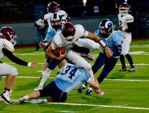 South Kitsap quarterback Mason Elena tries to go over a Rogers defender. (Mark Krulish/Kitsap News Group)