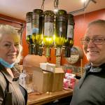 The couple has created wine labels that feature their canine pets, past and present (shown attached to wine bottles that make up a lamp). (Bob Smith | Kitsap Daily News)