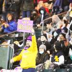 A super fan in the stands waves a sign of support at the start of the game.