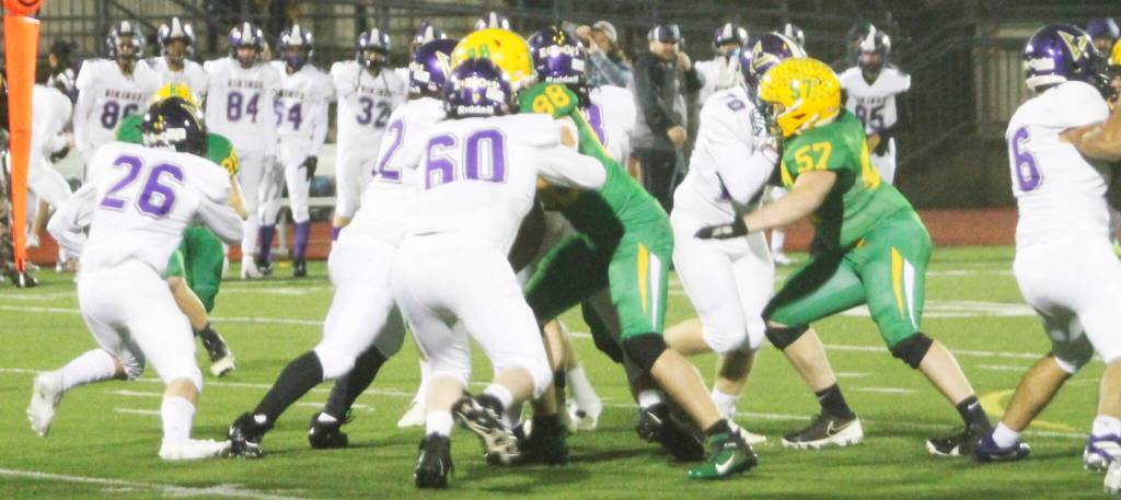 The Vikings offensive line blocks for running back Karsen Walsh (26) in the contest against Lynden.