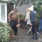 A staffer prepares to cut the bottom of the tree for a customer.