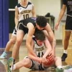 After falling to the floor Noah Davis (44) of Bainbridge gets tied up with Jonas La Tour (4) for a jump ball while Spartan Stanley Intihar (10) watches.