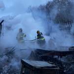 Poulsbo Fire Department firefighters work to extinguish hot spots after fire destroyed a home in the Sawdust Hill neighborhood early Monday morning. Courtesy Photos