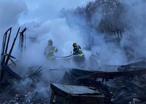 Poulsbo Fire Department firefighters work to extinguish hot spots after fire destroyed a home in the Sawdust Hill neighborhood early Monday morning. Courtesy Photos