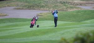 Viet Tran of Kingston follows through on his second shot after missing the numerous sand trips off the tee on Hole 1 at White Horse Golf Club. Steve Powell/North Kitsap Herald photos