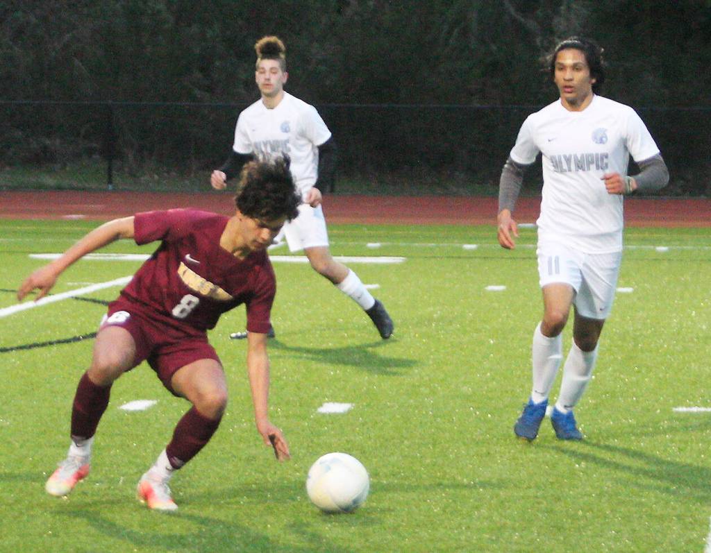 Daniel Moran of Kingston makes a move to try to get by two Olympic defenders.