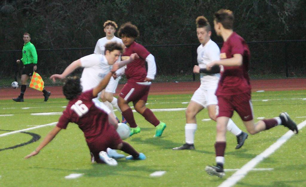 Anglas Alvaro of Kingston slides to try to steal the ball against Olympic.
