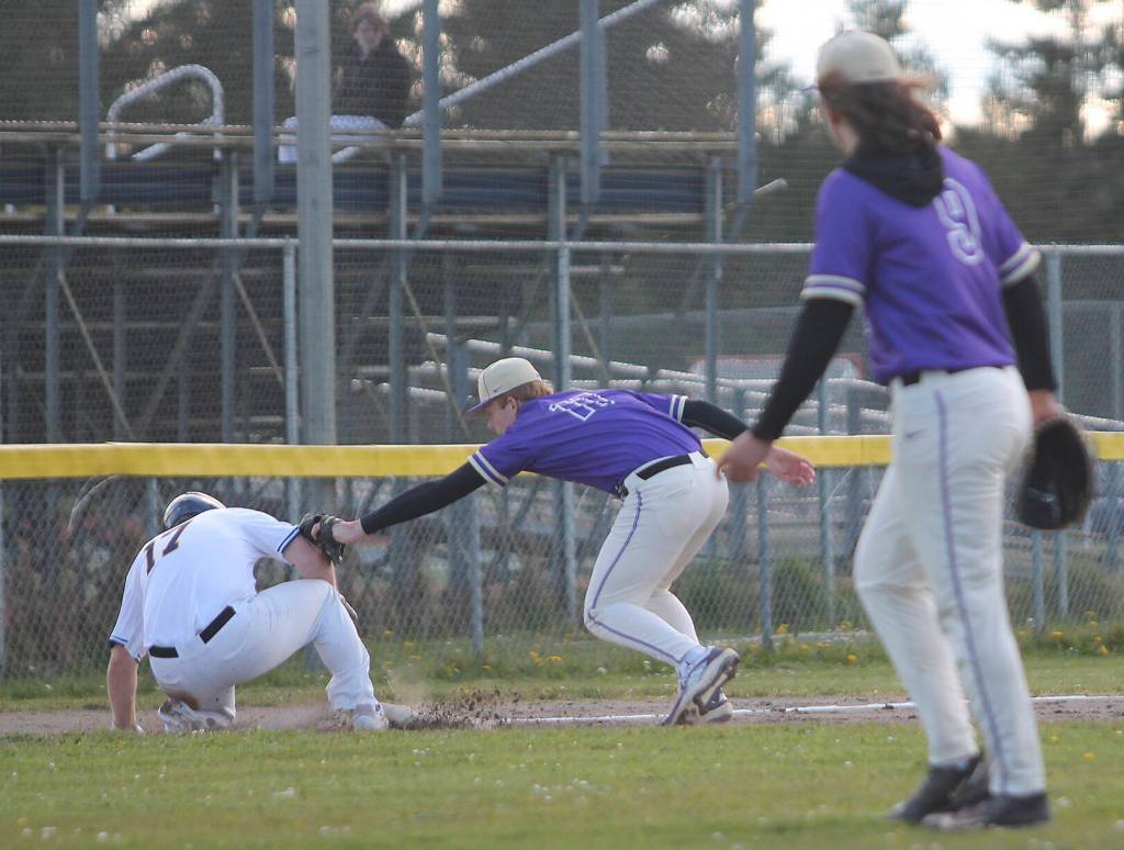 Noah Sorensen makes the tag at third base on Spartan Joey Hildebrandt, while NK teammate pitcher Dalton Brockett watches.