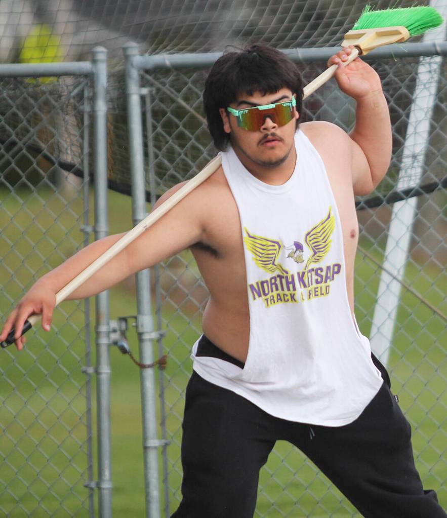 Viking sophomore Jesus Mares uses a broom to practice his form for the turns in the discus.
