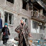 A Mariupol, Ukraine, family stands outside their ravaged apartment building. (WorldTodayNews.com courtesy photo)