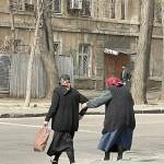 Two elderly babushkas lock arms to cross the street. (Courtesy photo)