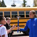 Harita Davies, a runner for the Sri Chinmoy Oneness-Home Peace Run, passes the Peace Torch to students at Kingston Middle School May 16 when the run passed through Bainbridge and Kingston. Nancy Treder/North Kitsap Herald photos