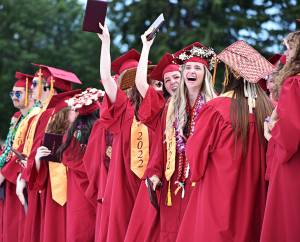 Several Kingston High graduates celebrate receiving their diplomas at their in-person graduation ceremony.